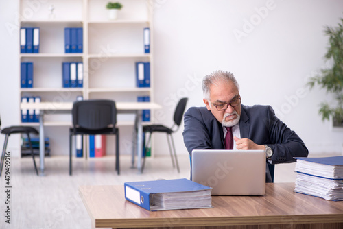 Old male employee and too much work in the office © Elnur