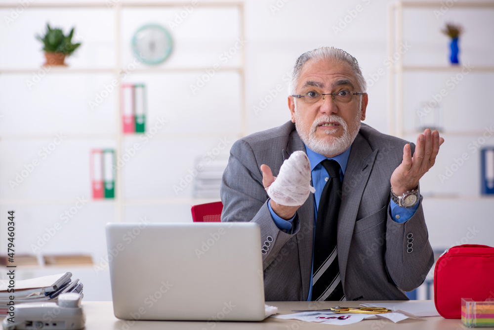 Old male employee cutting his hand in the office Old male employee cutting his hand in the office