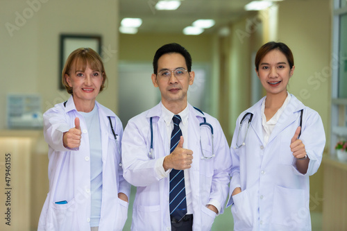 Portrait of the young Team Specialist Doctor wearing a stethoscope while standing with thumb up and looking away by Confident.