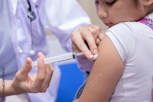 Close-up of Pediatrician doctor doing vaccination of a little girl.