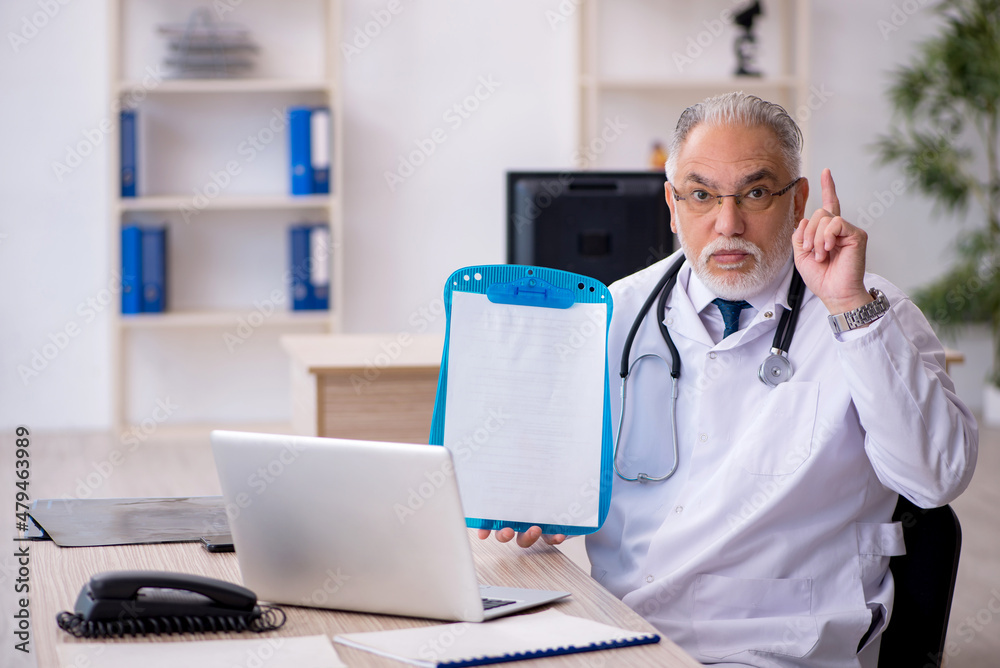 Old male doctor working in the clinic Old male doctor working in the clinic