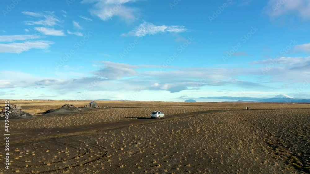 Aerial following Car driving on Offroad path, explore Iceland, Blue sunny day