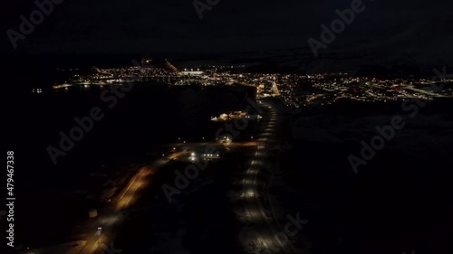 Illuminated Town Of Husavik At Night. The Whale Watching Capital Of Iceland. aerial forward photo