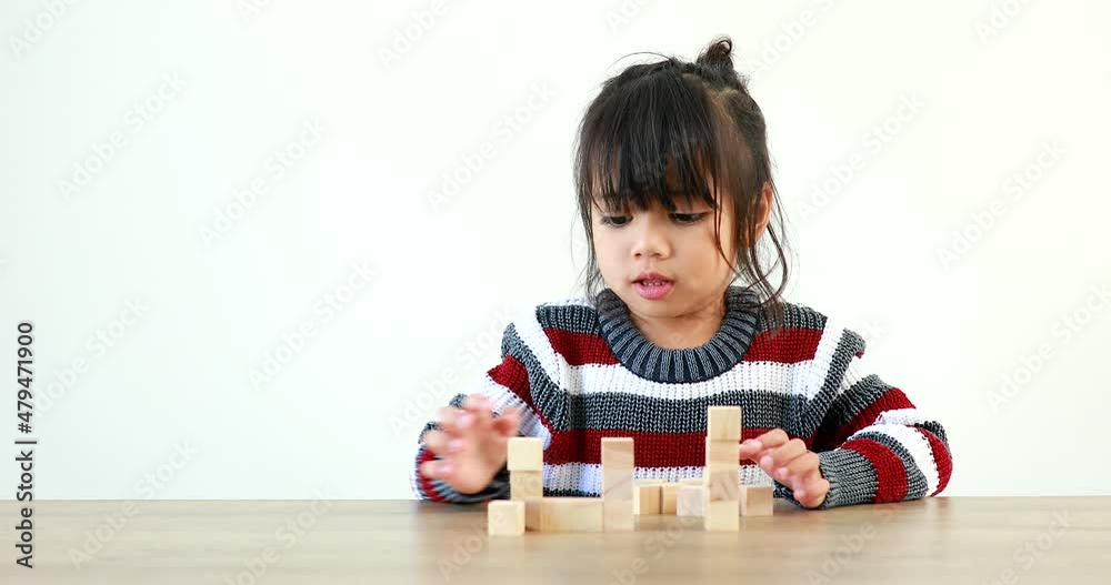 The little girl playing with wooden building blocks Jenga. Having fun and learning creativity. Developing learning and enhancing skills smart kid concept. The little girl playing with wooden building blocks Jenga. Having fun and learning creativity. Developing learning and enhancing skills smart kid concept.