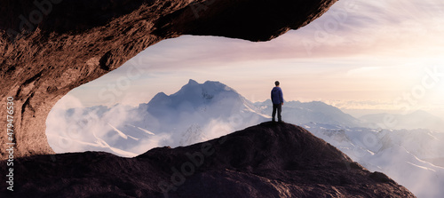 Fotografie, Obraz Dramatic Adventurous Scene with Man standing inside a Rocky Cave Landcspae