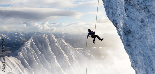 Fényképezés Adult adventurous man rappelling down a rocky cliff