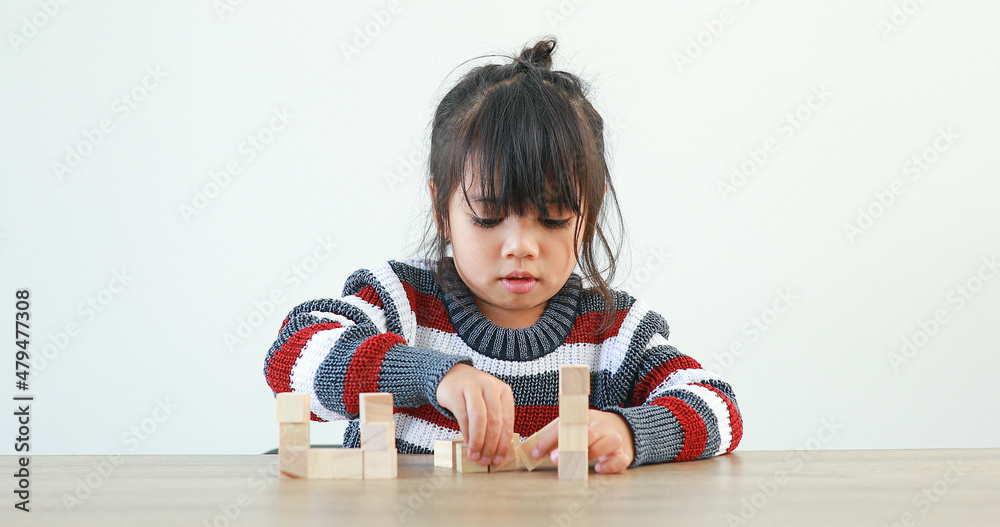 The little girl playing with wooden building blocks Jenga. Having fun and learning creativity. Developing learning and enhancing skills smart kid concept. The little girl playing with wooden building blocks Jenga. Having fun and learning creativity. Developing learning and enhancing skills smart kid concept.