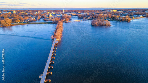 Autumn aerial view of the trestle trail heading across the lake to the other city on the other side at dusk