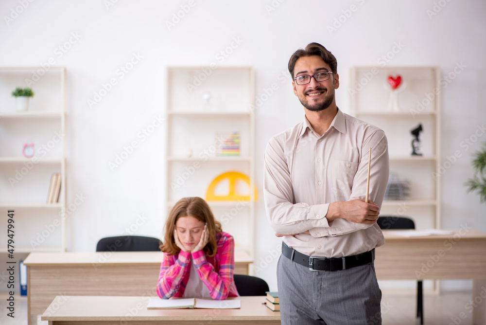 Young male teacher and redhead girl in the classroom Young male teacher and redhead girl in the classroom