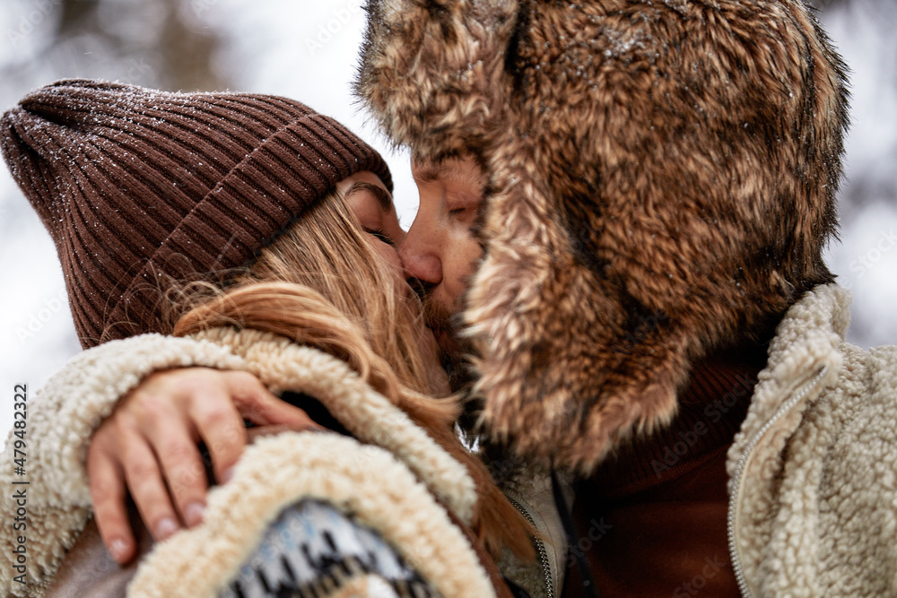 Young couple hugging and kissing in the Park in winter Young couple hugging and kissing in the Park in winter