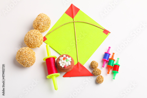Indian festival makar sankranti concept  Colorful kite  string and sweet sesame seed ball.