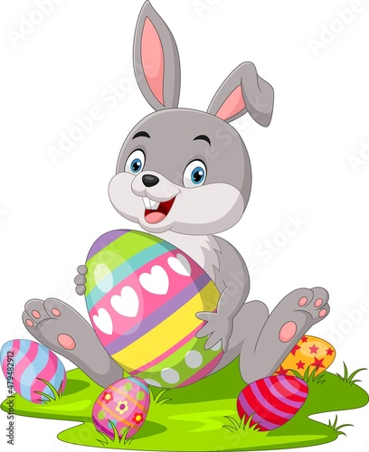 Cute little bunny with Easter egg in the grass