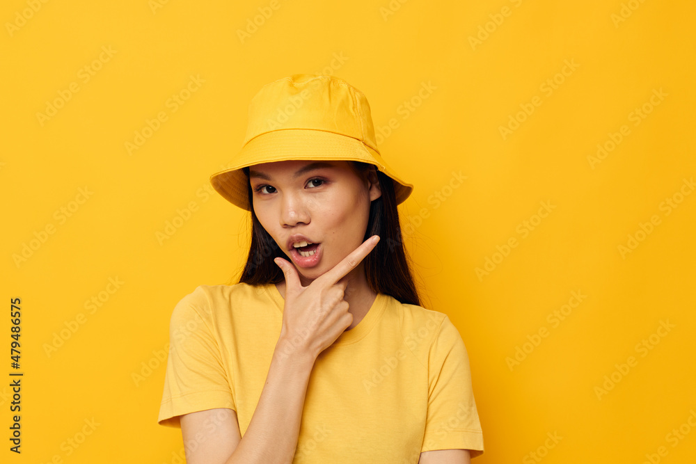 Portrait Asian beautiful young woman wearing a yellow hat posing emotions yellow background unaltered Portrait Asian beautiful young woman wearing a yellow hat posing emotions yellow background unaltered