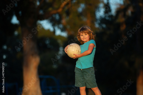 Excited child boy kicking ball in the grass outdoors. Soccer kids, children play football. Active ball games. © Volodymyr