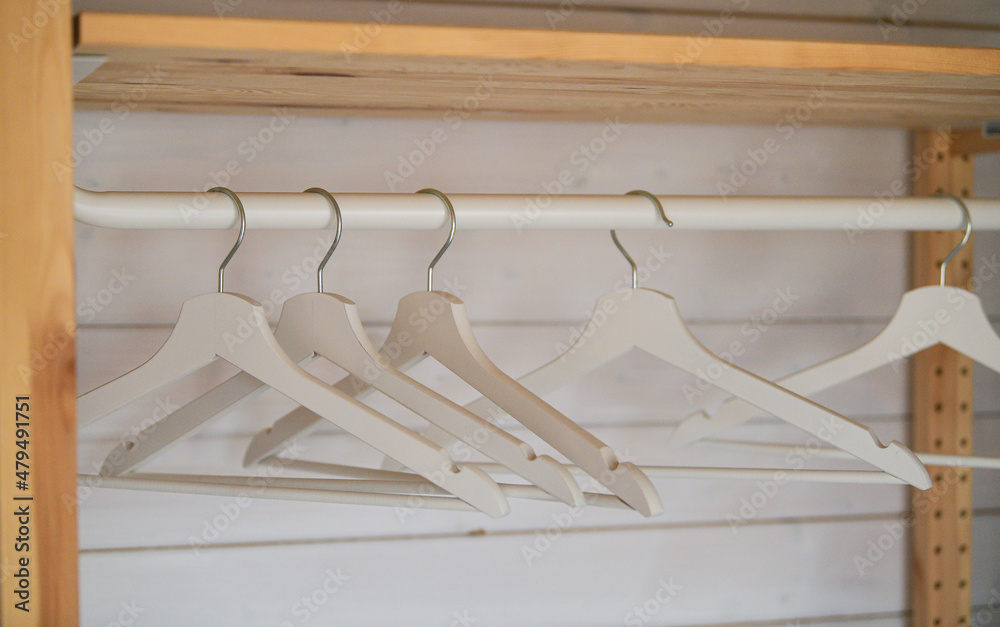 White wood hangers in a closet from a mountain cabin. Household interior details.