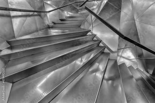 Silver metal spiral staircase modern staircase upwards with backlight. Abstract luxury minimalist architectural backdrop