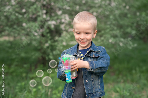 cute boy blowing bubbles in the park