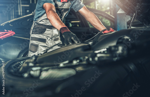 Car Mechanic Looking Under Vehicle Hood