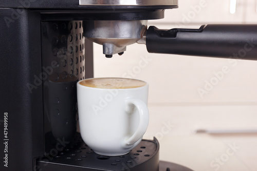 Making cup of espresso in carob coffee machine.