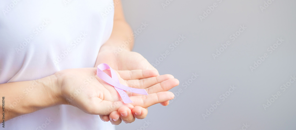 Naklejka premium World cancer day (February 4). Woman hand holding Lavender purple ribbon for supporting people living and illness. Healthcare and medical concept
