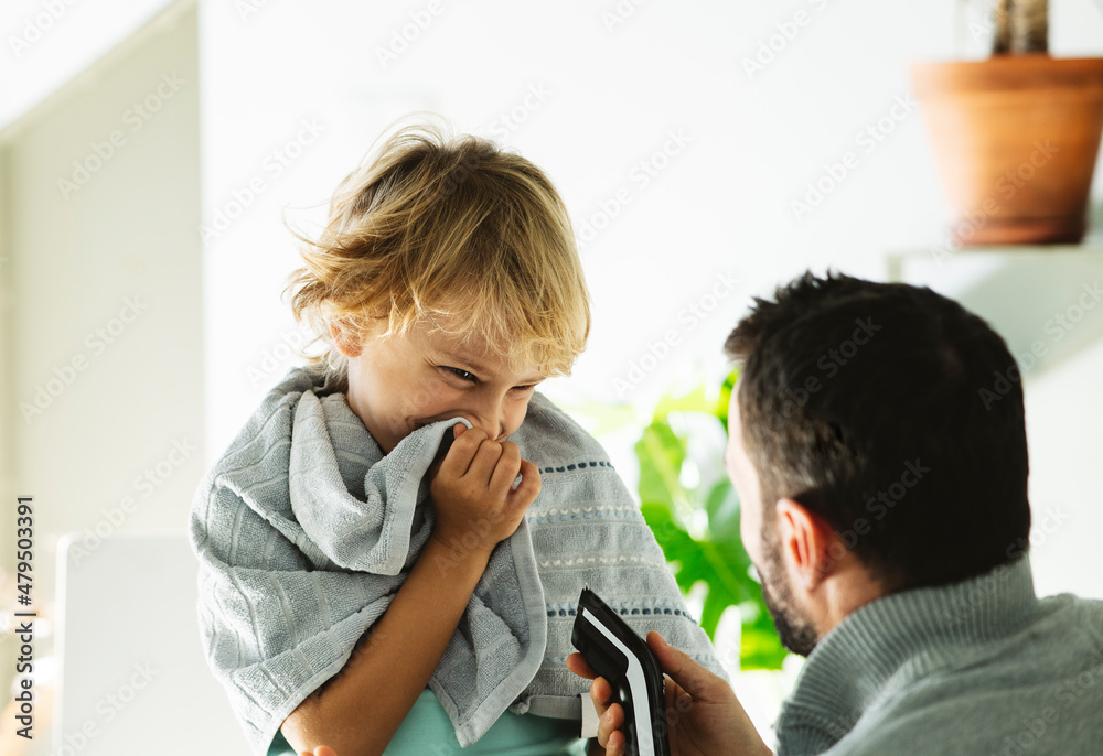 Happy boy looking at father with electric razor Happy boy looking at father with electric razor