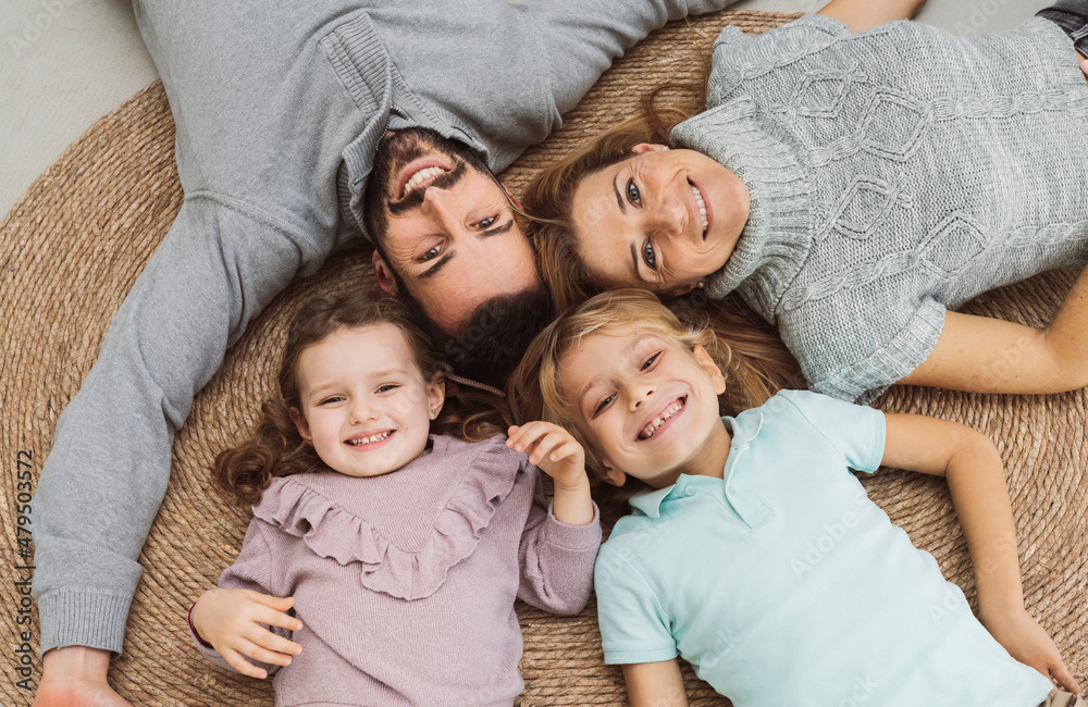 Happy family lying together on rug at home Happy family lying together on rug at home