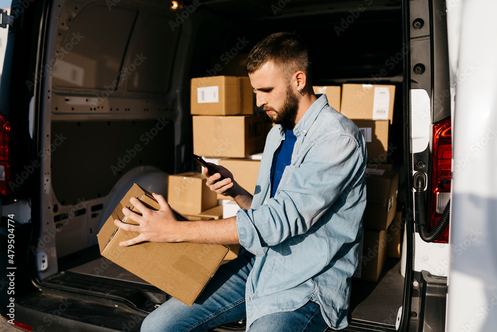 Delivery person scanning package in van Delivery person scanning package in van