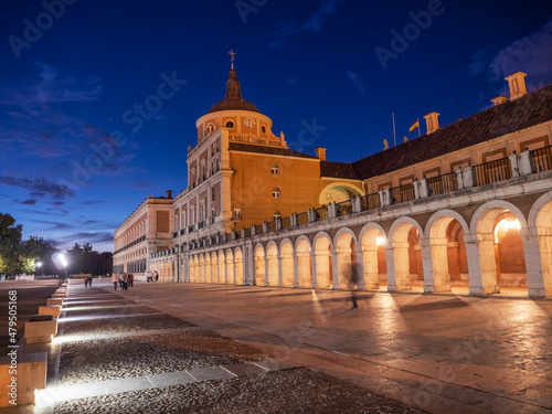 Spain, Community of Madrid, Aranjuez, Sidewalk stretching in front of Royal Palace Of Aranjuez at dusk photo