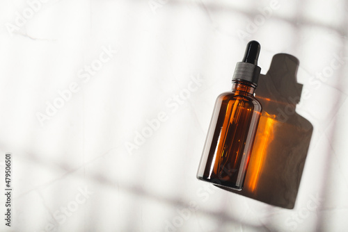 Fototapet Amber glass bottle with dropper pipette with serum or essential oil on a white background