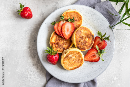 Cottage cheese pancakes or fritters with strawberry and natural yogurt. Healthy breakfast or lunch. Syrniki. Top view.
