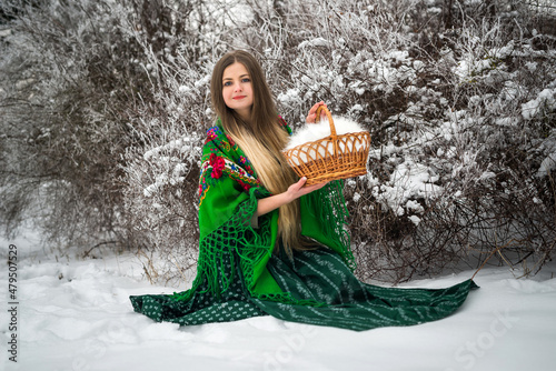 pretty woman in green drress and basket in winter day photo