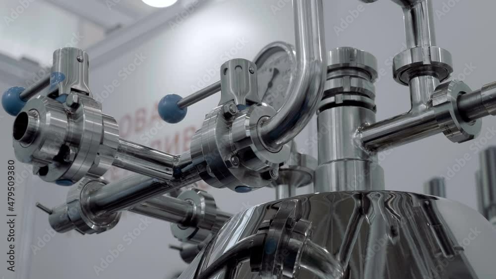 Shiny in the light, metal industrial equipment used in food, pharmaceutical, chemical industries. Shot in motion. Closeup Shiny in the light, metal industrial equipment used in food, pharmaceutical, chemical industries. Shot in motion. Closeup