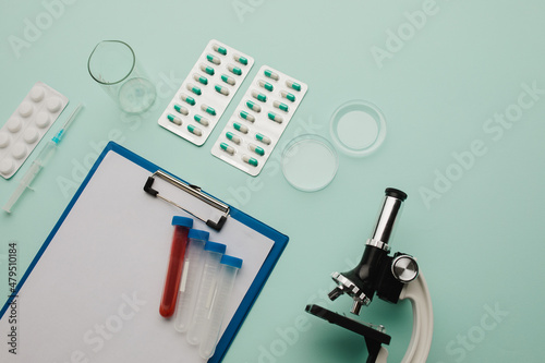 Laboratory test. Microscope, pills, test tube on blue background