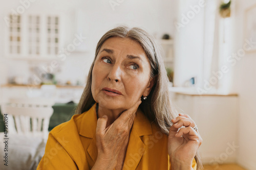 Photo Elderly woman feeling pain, swollen thyroid or lymph nodes