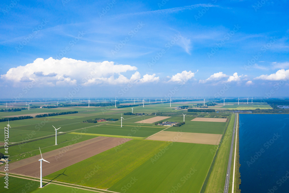 Aerial view of the Lauwersoog coastal landscape. Country road, wind turbines and agricultural fields next to the Wadden Sea. Near Groningen, Netherlands.