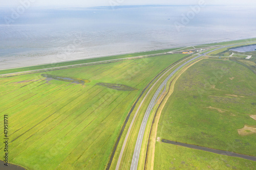 Aerial view of the Lauwersoog coastal landscape. Country road next to the Wadden Sea. near Groningen, Netherlands.