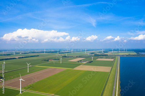 Aerial view of the Lauwersoog coastal landscape. Country road  wind turbines and agricultural fields next to the Wadden Sea. Near Groningen  Netherlands.