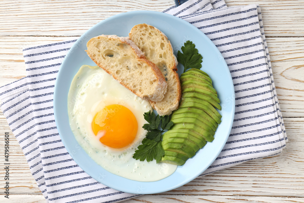 Plate of tasty breakfast on white wooden background