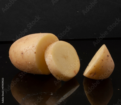 Patata cruda cortada sobre fondo negro. Raw potato cut out on black background. photo