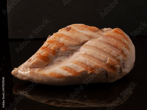  primer plano de pechuga de pollo a la plancha sobre fondo negro. grilled chicken breast close-up on black background. photo