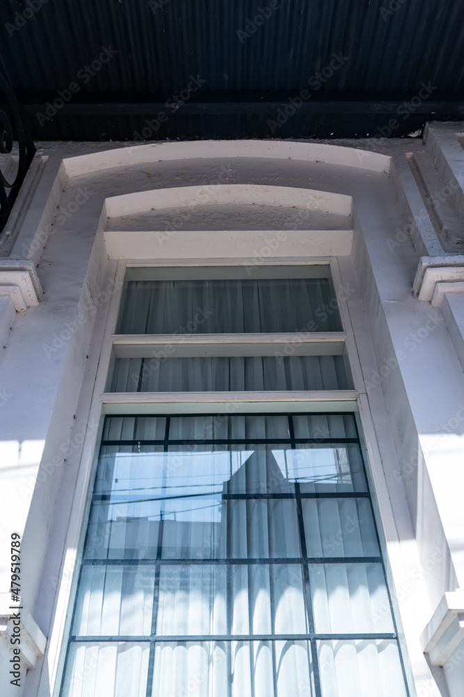 Obraz premium Low angle of vintage and old white wood square window from the heritage building architecture