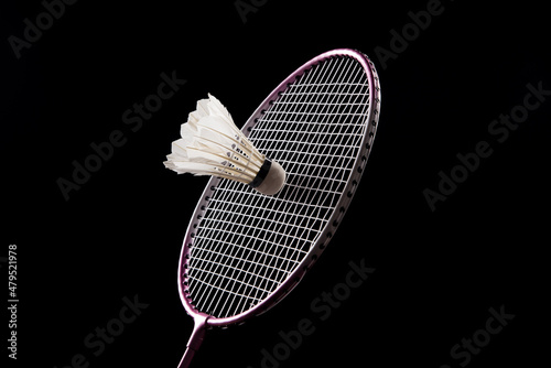 Badminton shuttlecock and badminton racket on black background photo