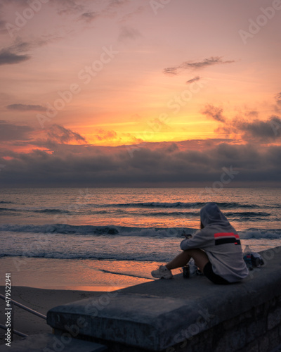 Chica frente a la playa en pleno atardecer