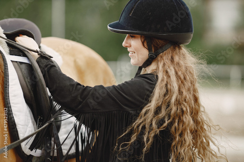 Portrait woman in black helmet with a horse © hetmanstock2