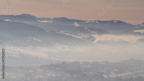 Slow pan over pollution covered village in winter valley photo