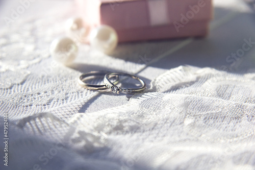 Selective focus. The wedding ringson the lace with ribbons and beads. Wedding preparations for the celebration. photo