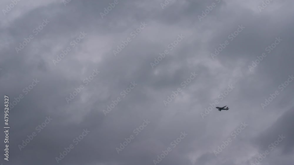 looking up at a British Airways Airbus A320 passenger jet plane flying through dark clouds in sky. looking up at a British Airways Airbus A320 passenger jet plane flying through dark clouds in sky.