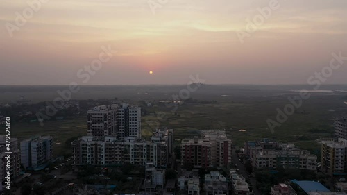 Golden Hour Sunset Over Residential Buildings In Vasai Near Mumbai City In India. aerial drone pullback photo