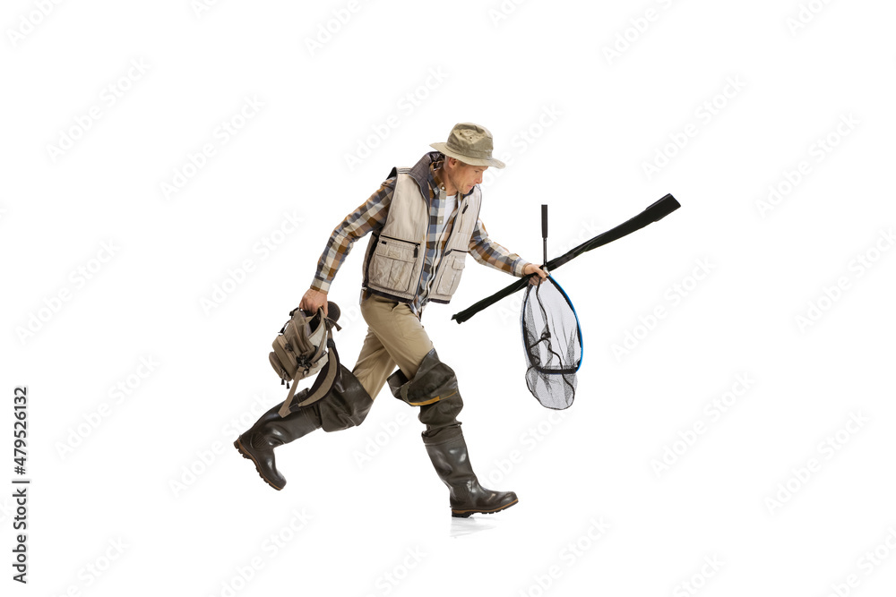 Fototapeta premium Portrait of young man, professional fisherman with fishing rod, spinning and equipment going to river isolated over white studio background