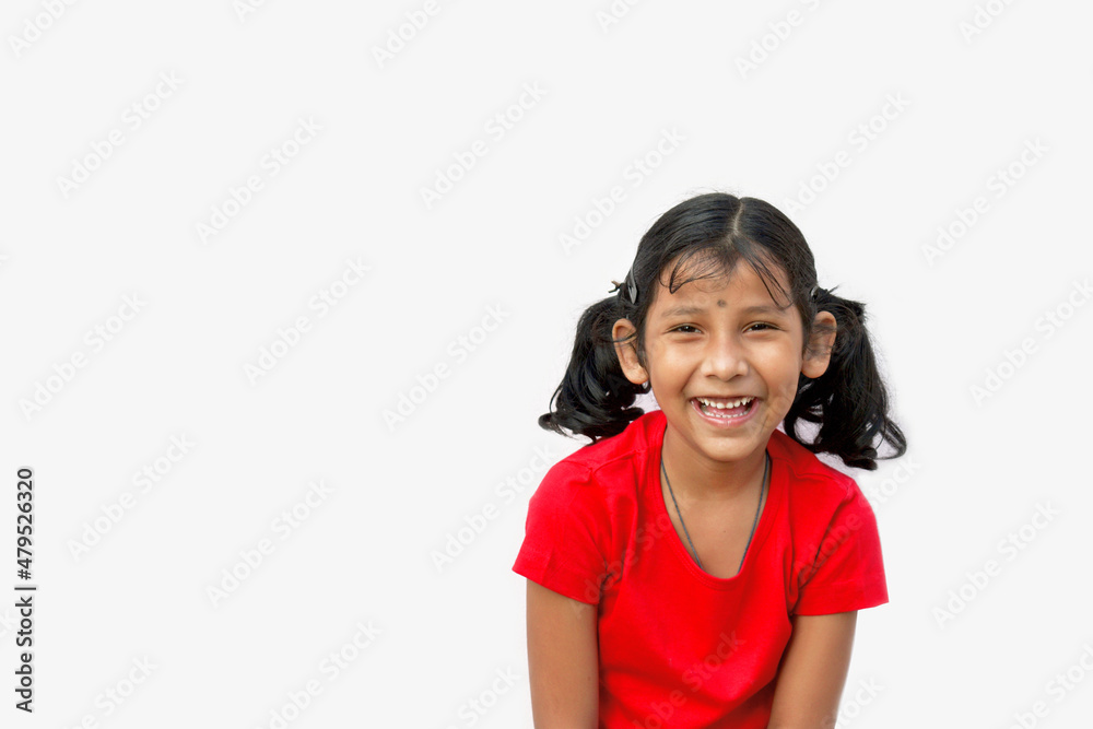 A girl laughing and smiling wearing red tshirt with braid light grey background A girl laughing and smiling wearing red tshirt with braid light grey background